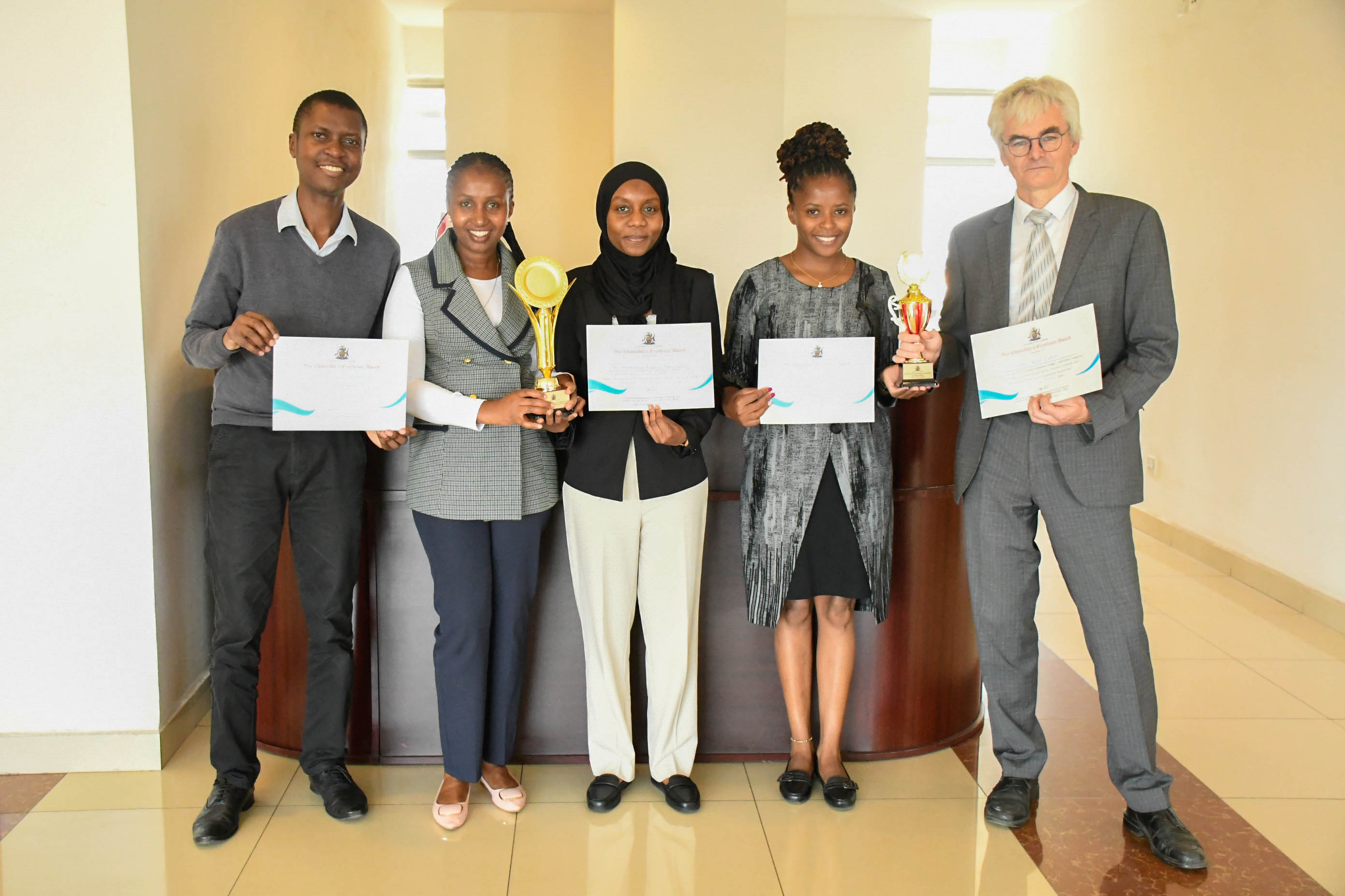 DUA staff show their Staff Recognition Awards 2025 trophies